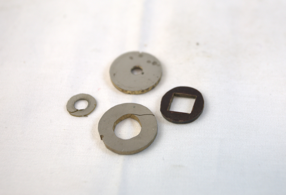 Runde gjenstander med hull i forskjellig metall.