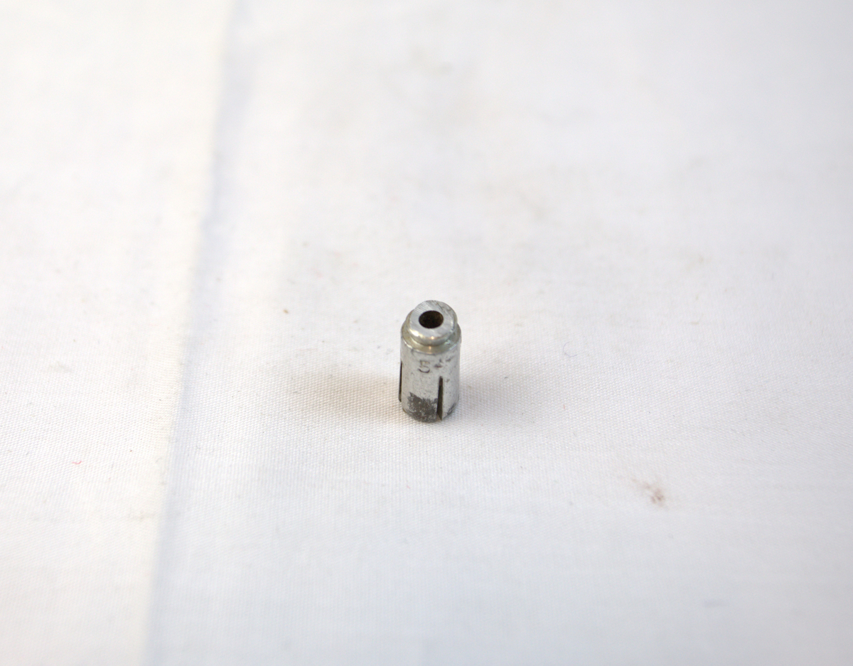 Sølvfarget lett metallgjenstand, trolig del av verktøy brukt i gullsmedvirksomhet. 