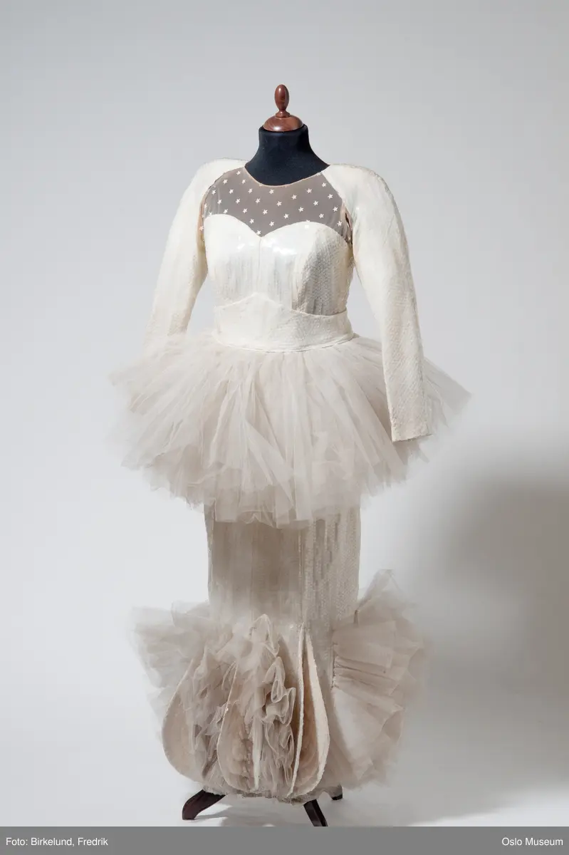 Langermet fotsid cremefarget kjole med, paljettbesatt med tilhørende utenpåliggende tyllskjørt.
