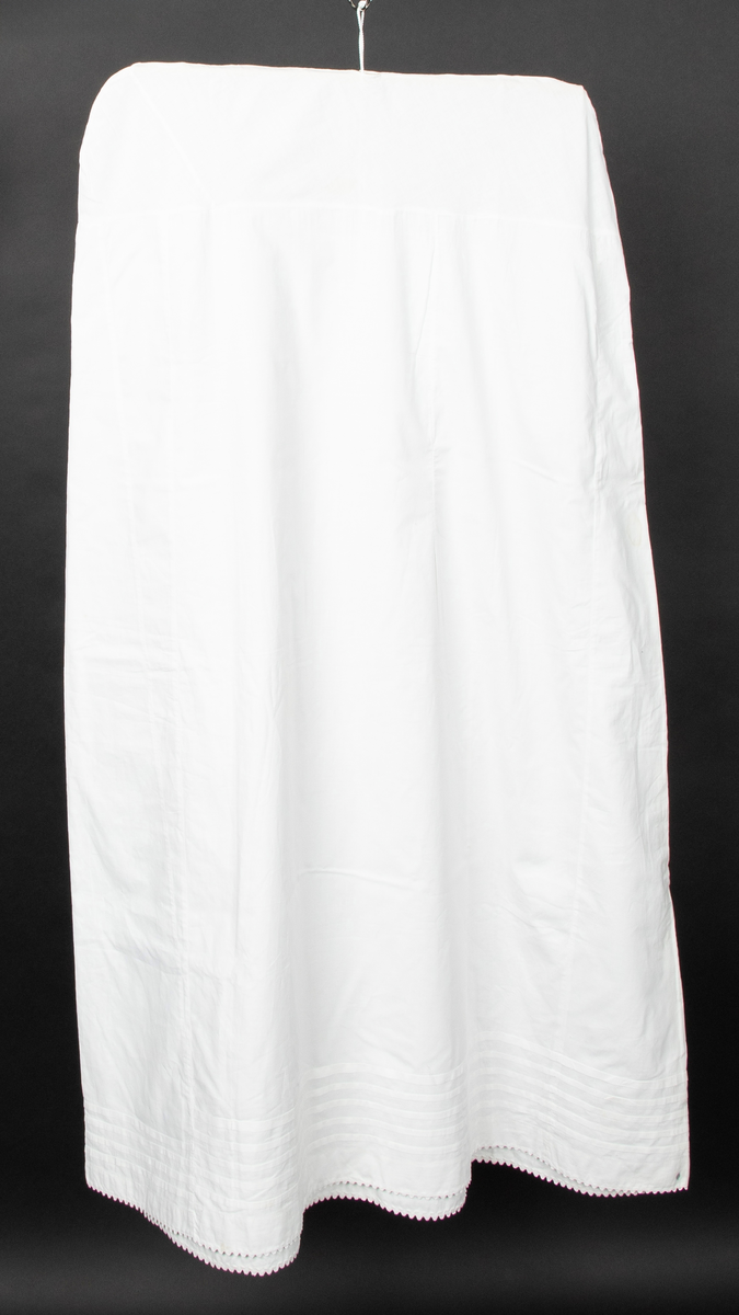 Klespose sydd av et gammelt bomullsunderskjørt. Skjøtet på 17cm fra livet. Hull til kleshenger. Midt på skjørtet kan man se to opprekkte sømmer.