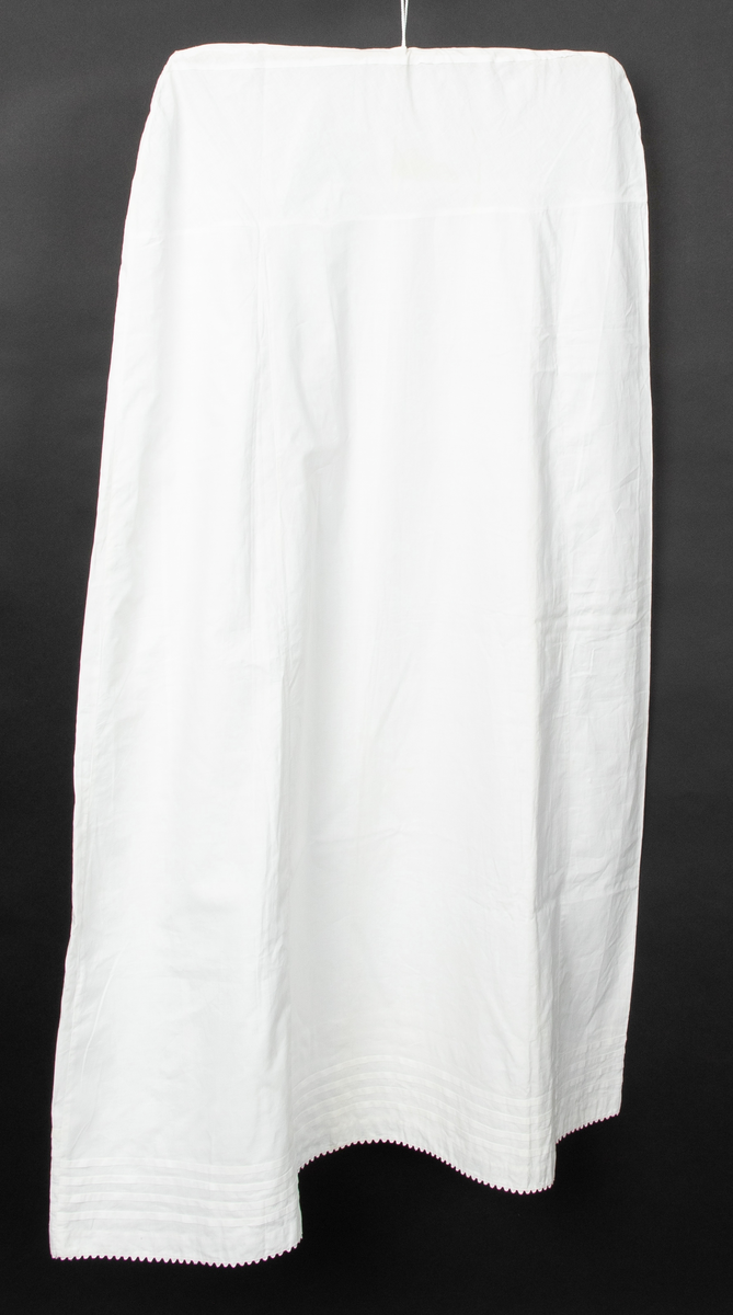 Klespose sydd av et gammelt bomullsunderskjørt. Skjøtet på 17cm fra livet. Hull til kleshenger. Midt på skjørtet kan man se to opprekkte sømmer.