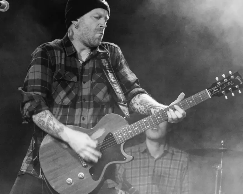 Svart/hvit bilde av Thomas Øian Mårud som spiller gitar på en scene