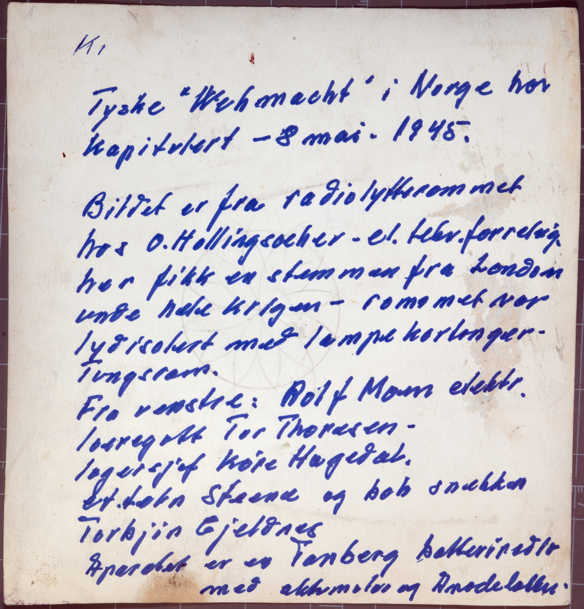 Tyske "Wehrmacht" har kapitulert - dagen er 8. mai 1945. Bildet er fra radiolytterommet hos O. Hollingsæter el. teknisk forretning i Kristiansund. Her fikk en stemmen fra London under hele krigen. Rommet var lydisolert med lampekartonger - bl.a. fra Tungsram. Fra venstre: Rolf Moen (elektriker), Tor Thoresen (læregutt), Kåre Hagedal (lagersjef), el. tekniker Steene og snekker Torbjørn Gjeldnes. Apparatet vi ser er en Tandberg batteriradio. Fra en samling gitt til museet 08.04.2025 av Eivind Thoresen.