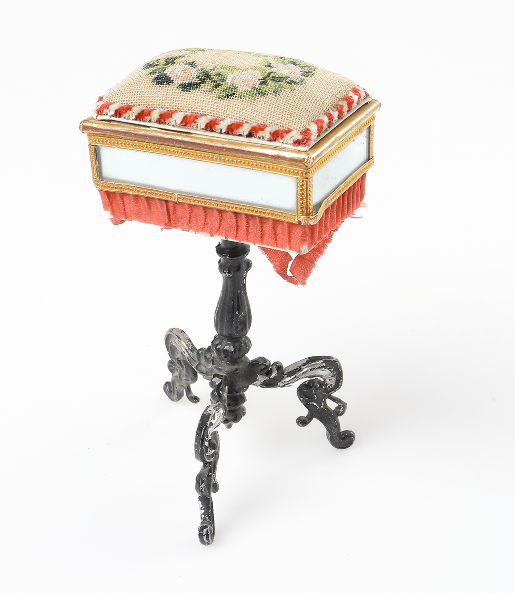 Nåldyna, på fotställning av metall, prydd med speglar.