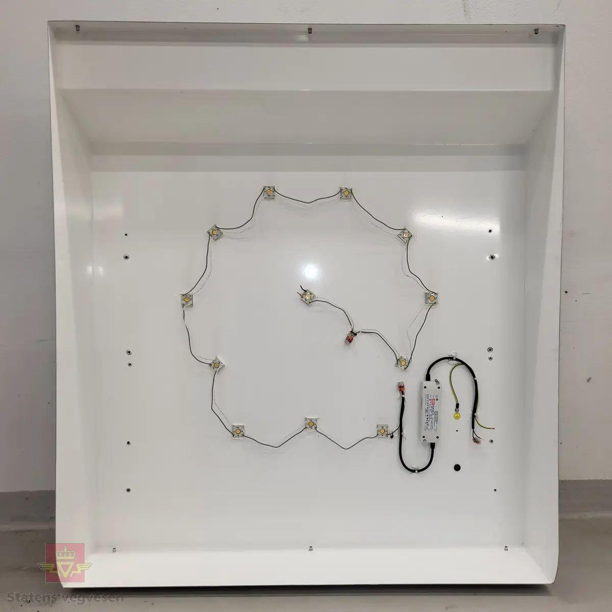 Skiltkasse med lokk. Den har led-belysning innvendig, med Shell-logo på forsiden. I hovedsak lagd av plast og aluminium, flerfarget.