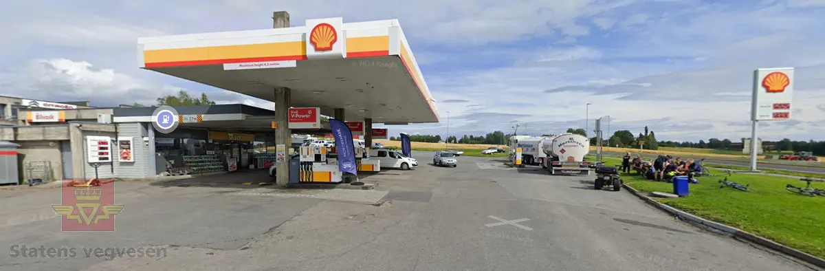 Skiltkasse med lokk. Den har led-belysning innvendig, med Shell-logo på forsiden. I hovedsak lagd av plast og aluminium, flerfarget.