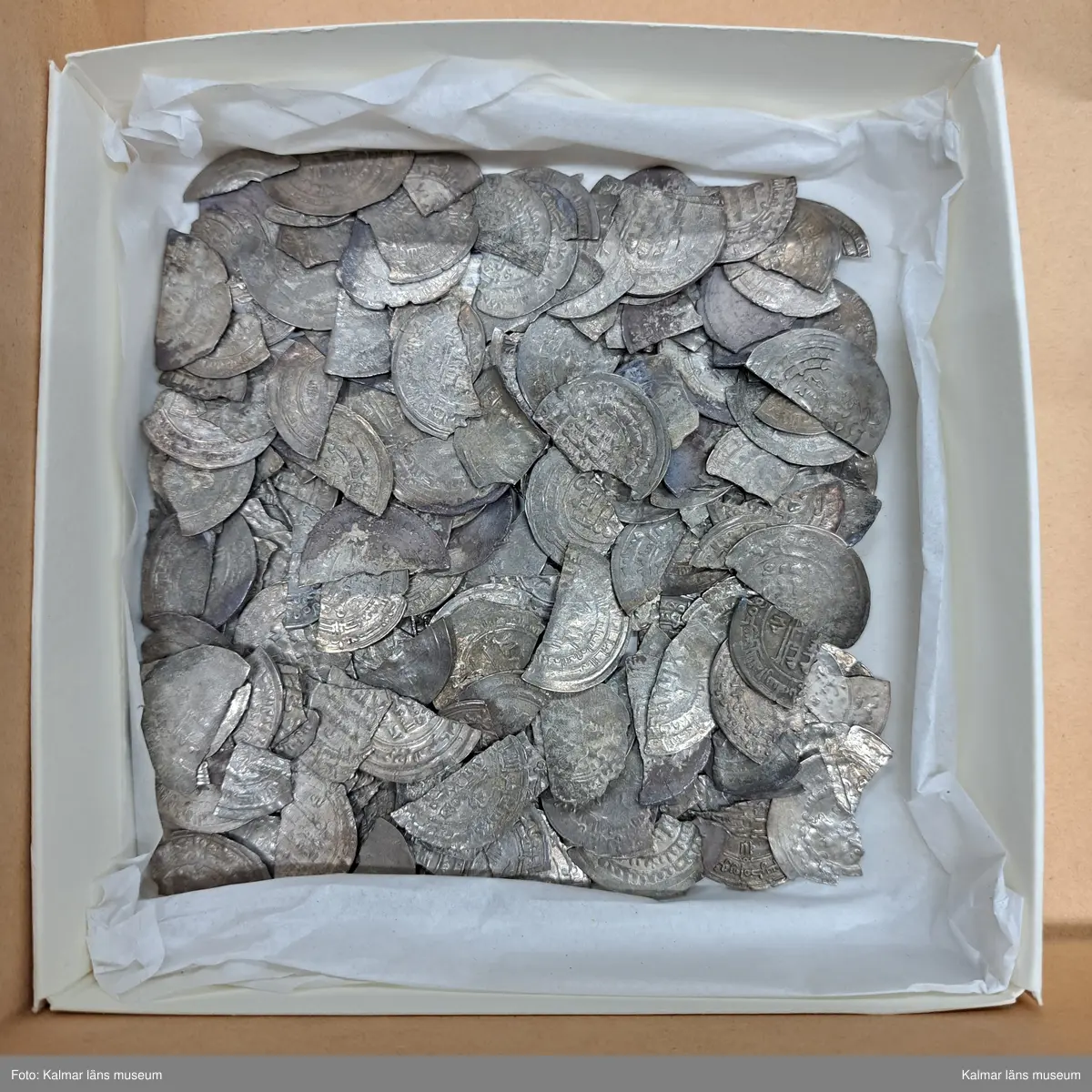 KLM 23964. Skattfynd, av silver. 1111 st mynt, 1 st hängkors, 35 st runda plantsar (varav 16 fragment), 7 st fragment av smycken (hacksilver).