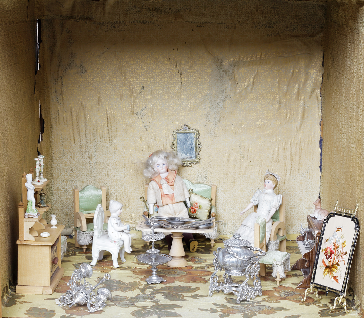 Dockskåp med tillhörande inredning. Brunbetsat träskåp försett med glasförsedda pardörrar. Skåpet har tre våningsplan med fem möblerade rum. Inredning från 1890-talet. Skåpet står på fyra svarvade fötter.