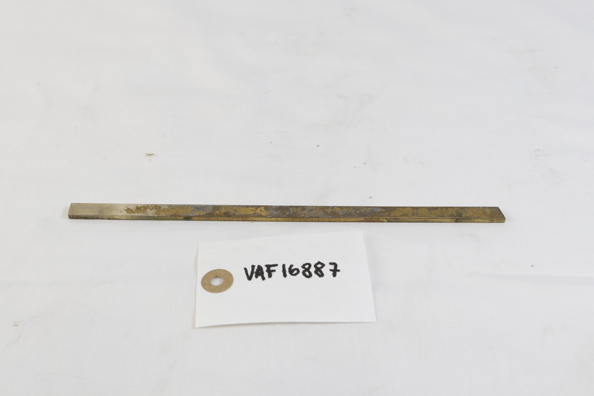 Avlang og oksidert metallgjenstand. Trolig brukt som materiale i gullsmedvirksomhet.