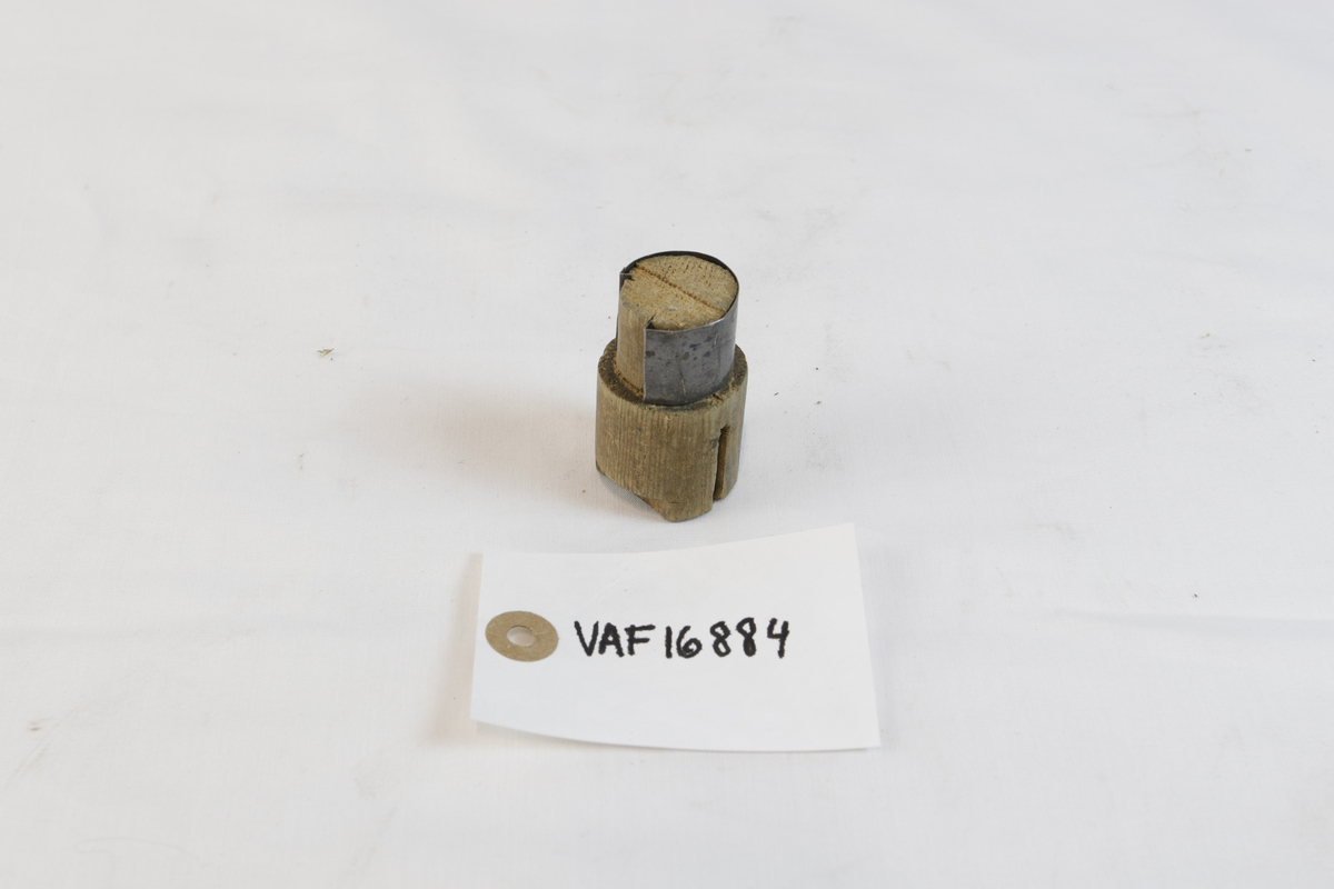 Sirkelformet tregjenstand med metallplate som delvis går rundt. 