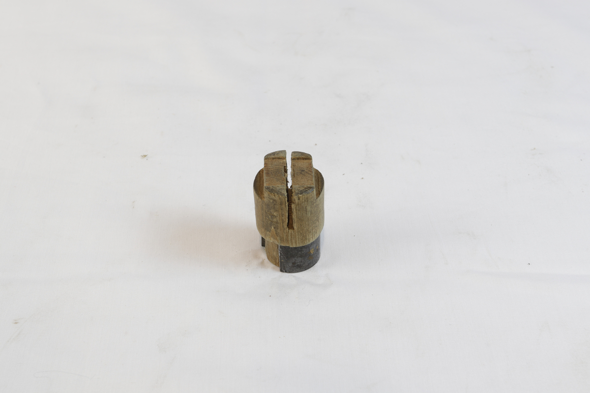 Sirkelformet tregjenstand med metallplate som delvis går rundt. 