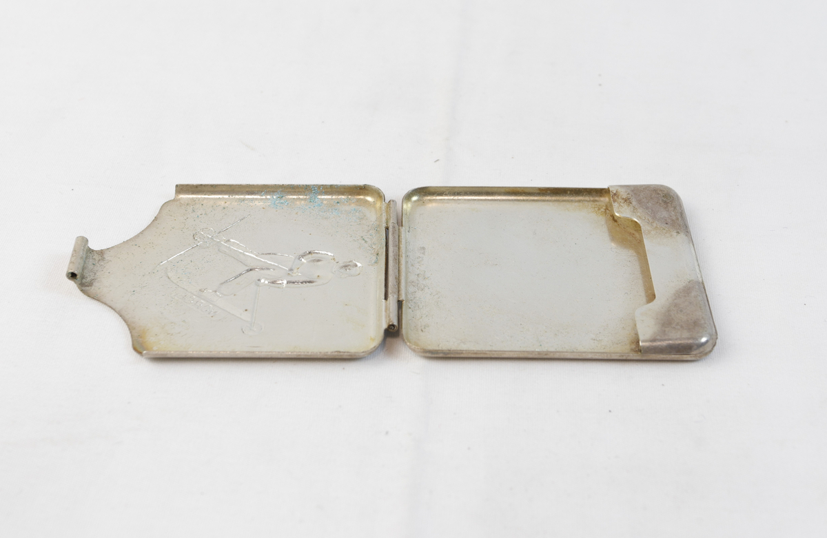 Etui i sølv med figur på ski. Etuiet var trolig opprinnelig brukt til oppbevaring av sigaretter. 