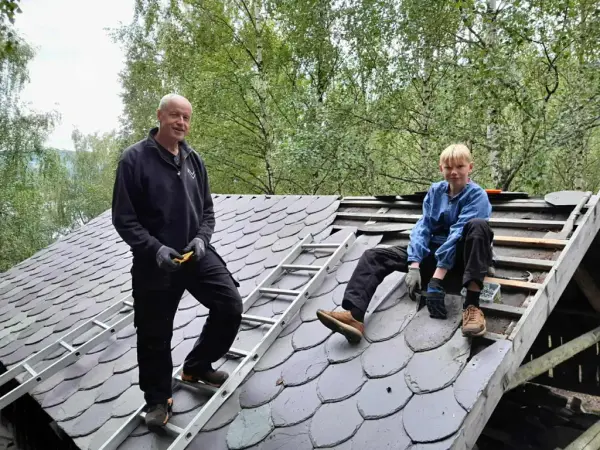 Instruktør og lærling på eit tak under taktekkingsarbeid