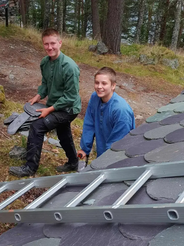 To gutar som bærer opp skiferplater