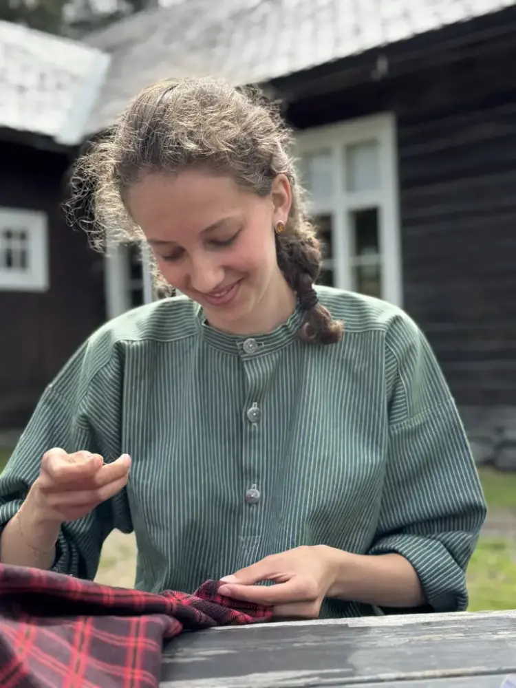 Jente i grøn busserull som syr