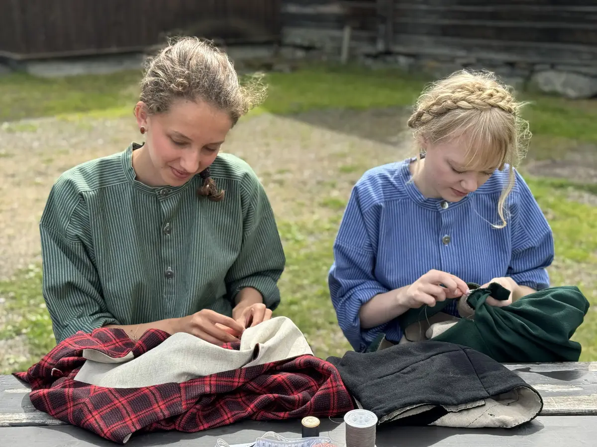 To jenter som reparerar bunad