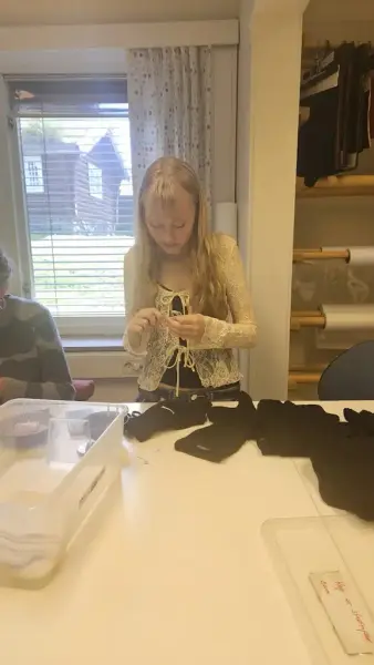 Jente med lyst hår som syr