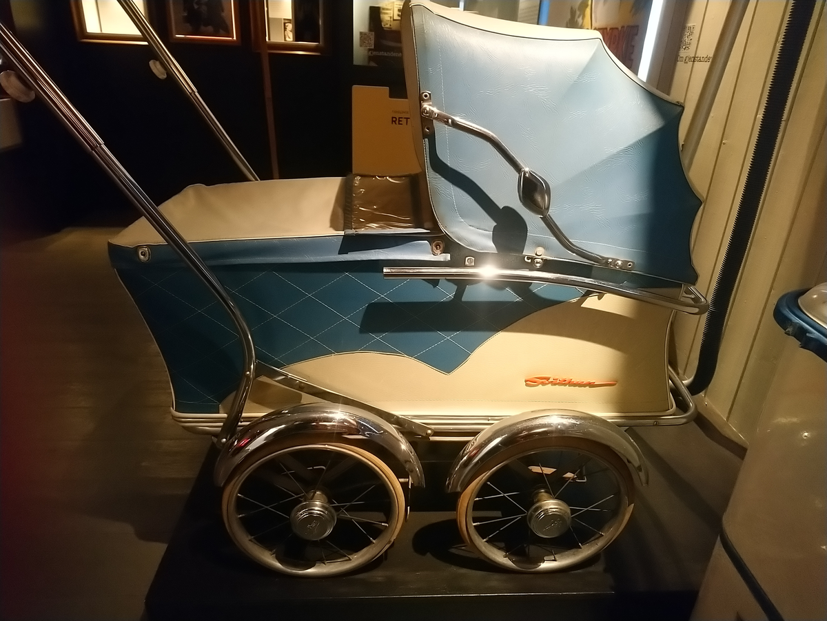 Gitt av Gerd Dammen (f.1929).

Barnevognen er blå og ble brukt av ulike barn i familien. 
Den ble først tatt i bruk i 1958 av fetter Johnny Dahl, Så av Tor Erling Haskerud så av Bente Dammen (f.1962). Den ble oppevart på loftet inntil den ble gitt som gave til Kvinnemuseet,
