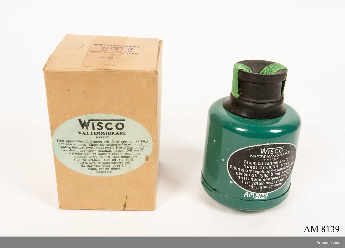 Vattenmjukare Wisco. Tillverkad av grön och svart plåt och gummi. Klistrad etikett  "Wisco vattenmjukare Patent". I botten med vit oljefärg "C". Apparaten skall sättas på en vattenkran. Vattnet får rinna igenom med högst 4 min/liter (sic!) tryck. Rening av apparaten görs med 2 matskedar salt som läggs i gummivalsen varefter en liter vatten sakta får rinna igenom. Bruksanvisning finns i förpackningen. Ingår i fotomaterielsats 7 låda 2.