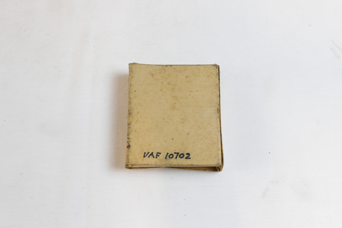 Rektangulær eske som inneholder sirkulære sålesparer med tre pigger.
