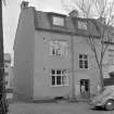 Gårdsinteriör från Hunnebergsgatan 16 i Linköping. Fotoåret 1961 stod tomtens andra, kända generation hus på platsen, en påbyggnad mot västra gaveln till Hunnebergsgatan 14. Den tillbyggda huskroppen hade ersatt ett av de många ålderdomliga trähus som fordom kantat gatan. Under senare delen av 1970-talet kom turen till bildens hus att lämna plats för en ny huslänga.