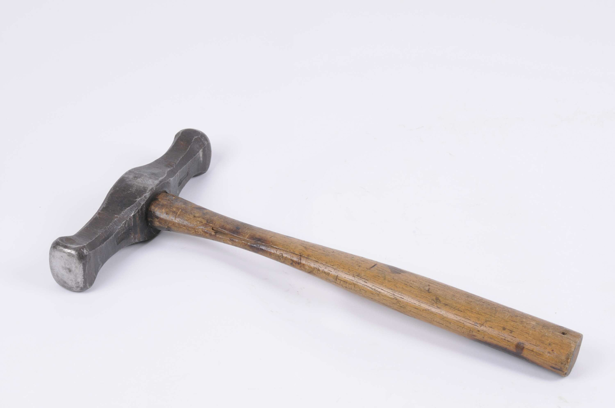 Hammare med skaft av trä.
Märkt: på huvudet J Julius Marcus samt två symboler varav en är en skiftnyckel.