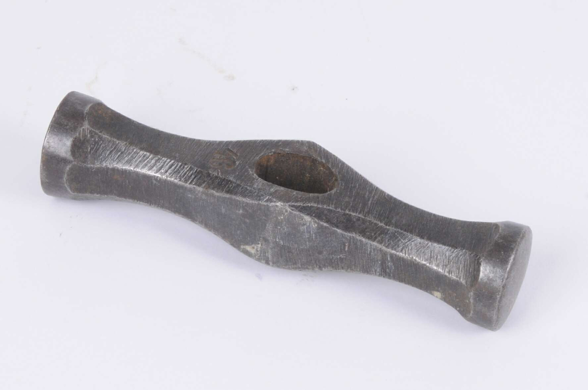 Handhammare utan skaft. Två runda platta slagytor.
Märkt: 46.