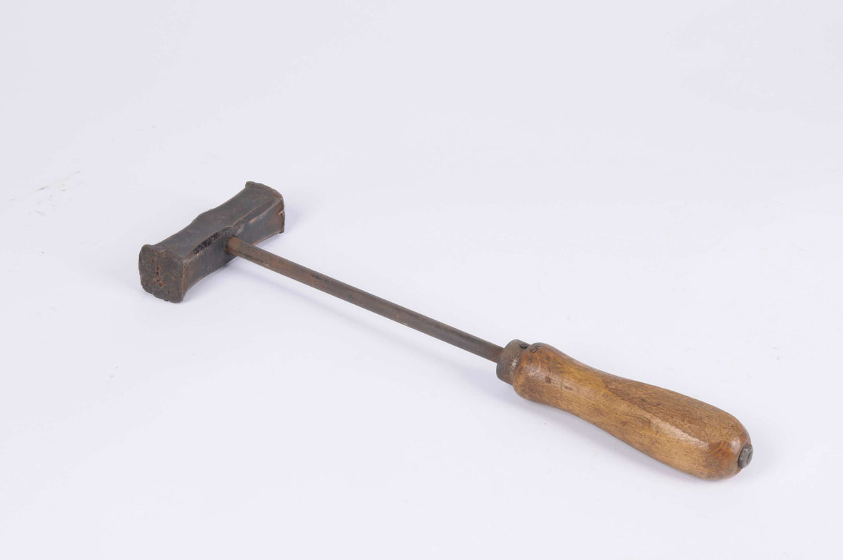 Handhammare med kopparhuvud och skaft av järn, det senare sitter ihop med ett skaft av trä. Två plana slagytor. En mutter håller huvudet vid skaftet.