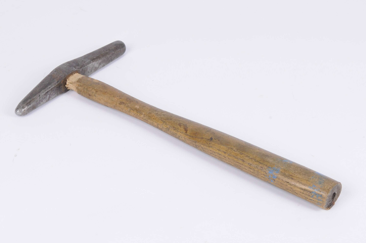 Drivhammare, liten med två slagytor, båda rundade men den ena lite spetsigare. Rester av blå färg på skaftet. Huvudet sitter löst. Litet borrat hål i änden på skaftet.
Märkt: på huvudet 25, på skaftet K.