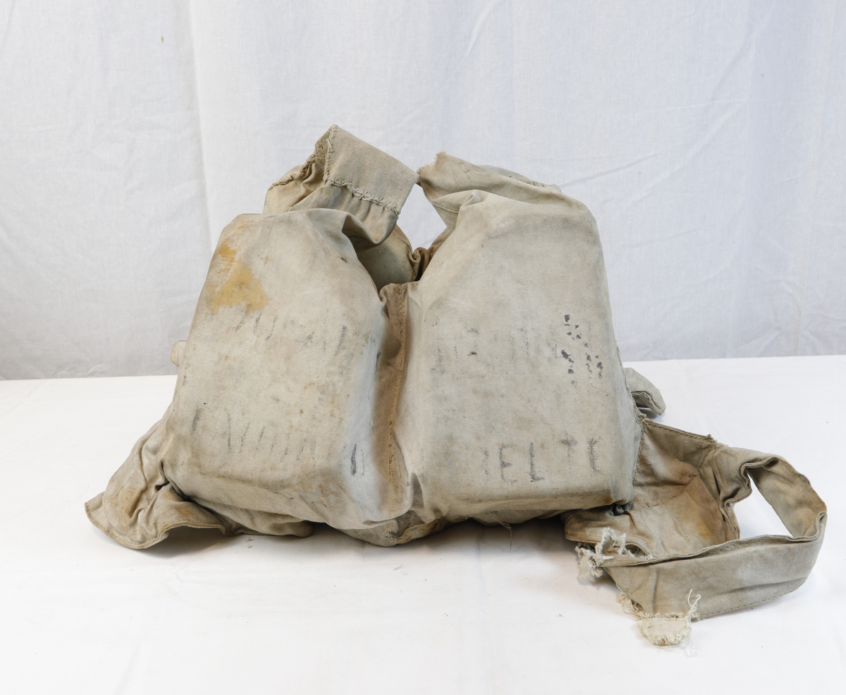 Livvest av tøy med fire flyteelementer. Formet slike at den kan tres over hodet og knyttes på sidene