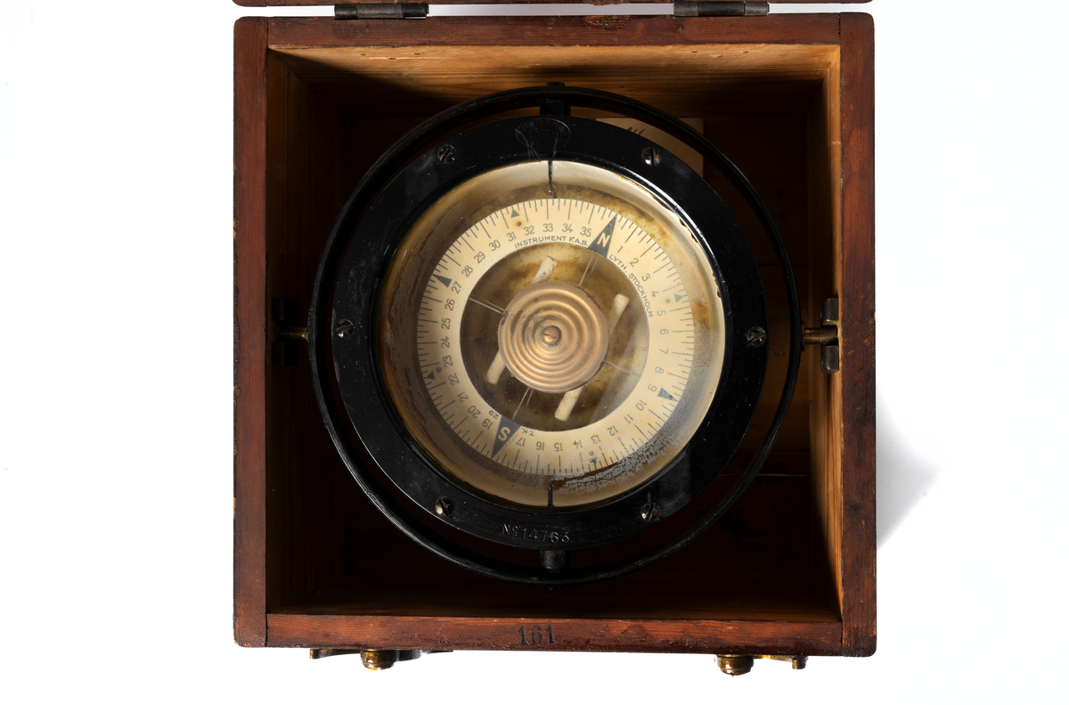 Trälåda låda till spritkompass med kardansk upphängning (del 1) . Med nakterhus (2). Lådan är av björk och har skjutlock. Fernissad. Innehåller sex stycken kompensationsmagneter.