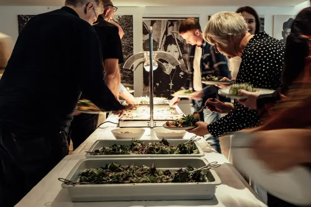 Seks folk som forsyner seg med mat.