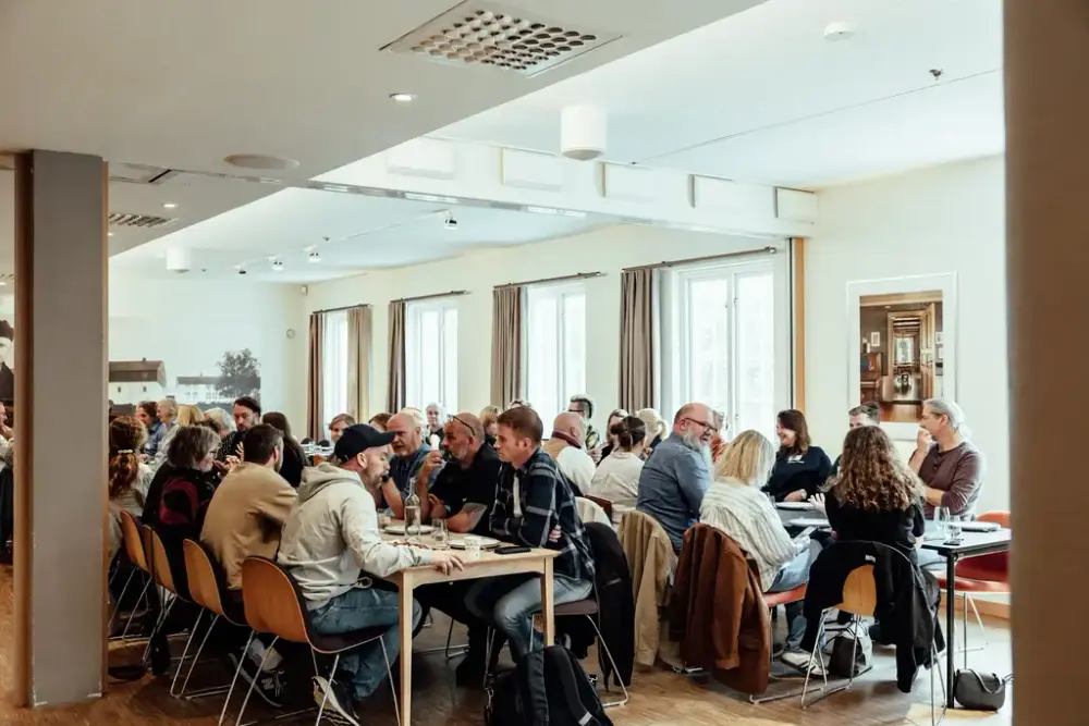 Mange folk som spiser langs to langbord