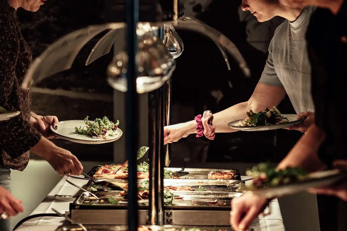 Hender som forsyner seg med mat