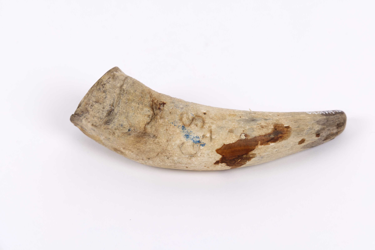 Fetthorn funnet ved Kongshavn ved Alvøen i Bergen. Kremmerhusformet fetthorn av bein med rett kant øverst. Initialer og skipsnavn innrisset sammen med ett anker. Del av en last med flere fetthorn sammen med restene av ett skog.