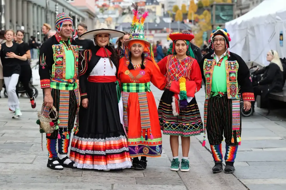 Vi ser stolte peruanere i sine fargerike folkedrakter, 2 menn og 3 damer