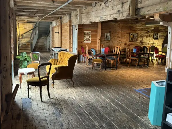 Vi ser her et nydelig lokale med flotte gamle tømmervegger, rommet er dekorert med eldre møbler, som gjør at det ser varm, koselig og innbydende ut