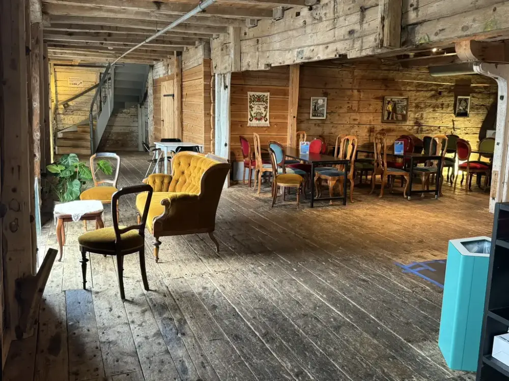 Vi ser her et nydelig lokale med flotte gamle tømmervegger, rommet er dekorert med eldre møbler, som gjør at det ser varm, koselig og innbydende ut