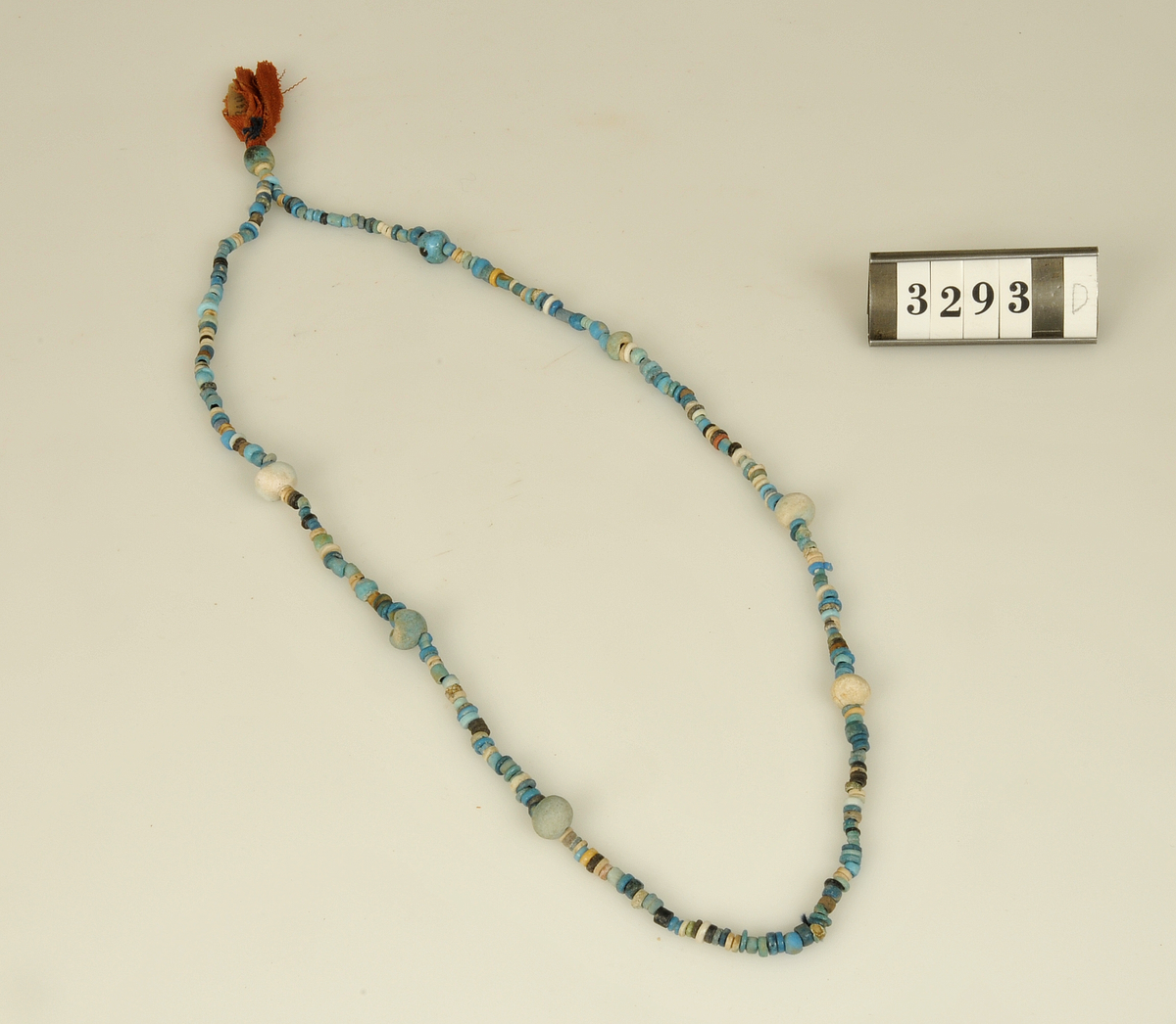 Gravfynd.

6 st. halsband av turkosfärgade fajanspärlor.
Tre av dem har vidhängande textila rester i form av linne-
remsor hopsatta till tofsar. Två naturfärgade, en röd.
Fyra av halsbanden har fastsatta fajansfigurer: 
en scarabé, två faraofigurer och en apgud.

Har tillhört de Adelsköldska samlingarna.
