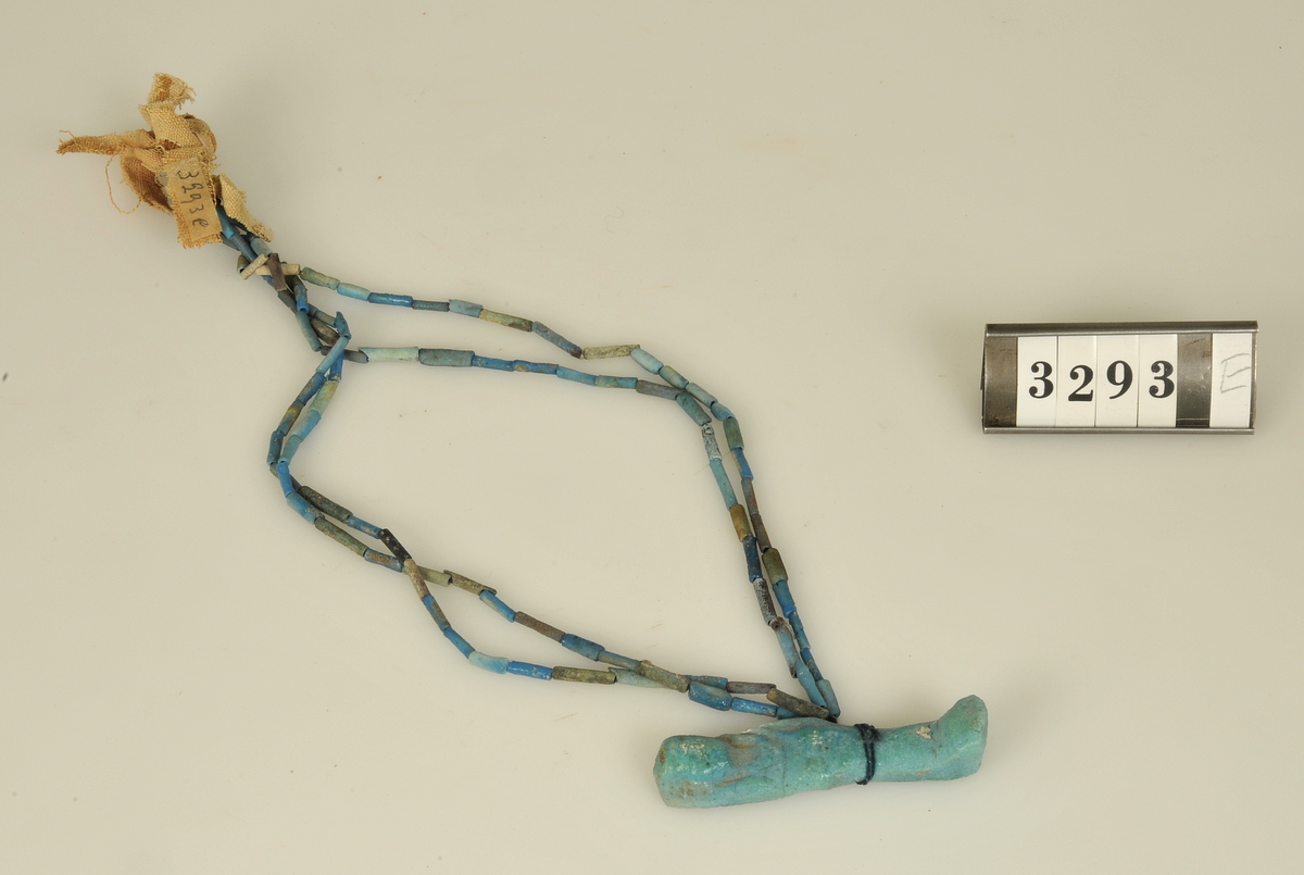 Gravfynd.

6 st. halsband av turkosfärgade fajanspärlor.
Tre av dem har vidhängande textila rester i form av linne-
remsor hopsatta till tofsar. Två naturfärgade, en röd.
Fyra av halsbanden har fastsatta fajansfigurer: 
en scarabé, två faraofigurer och en apgud.

Har tillhört de Adelsköldska samlingarna.
