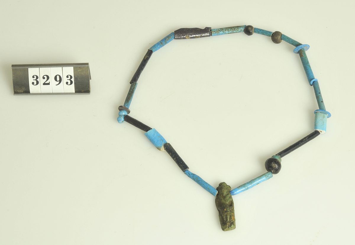 Gravfynd.

6 st. halsband av turkosfärgade fajanspärlor.
Tre av dem har vidhängande textila rester i form av linne-
remsor hopsatta till tofsar. Två naturfärgade, en röd.
Fyra av halsbanden har fastsatta fajansfigurer: 
en scarabé, två faraofigurer och en apgud.

Har tillhört de Adelsköldska samlingarna.
