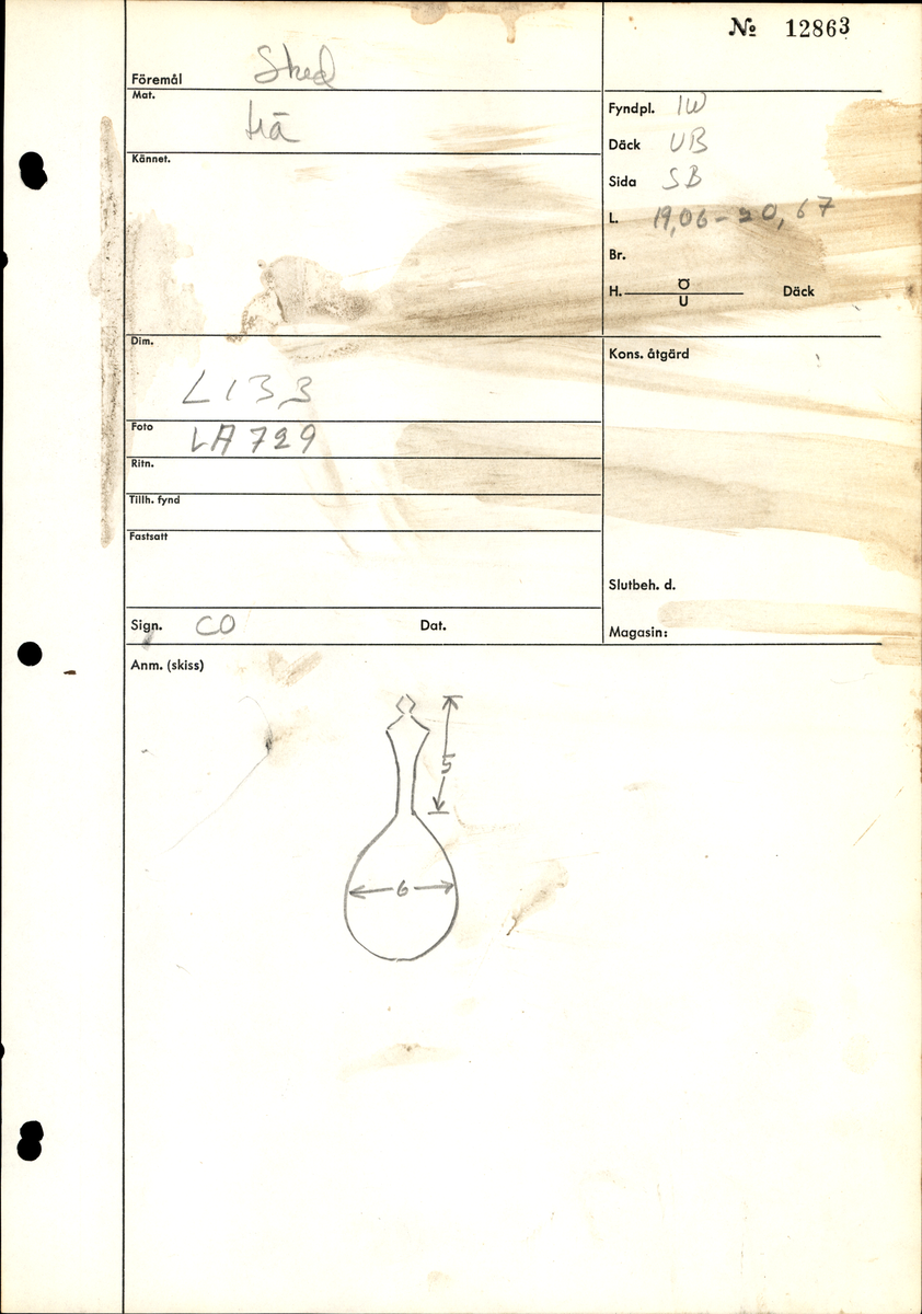 En träsked. Skeden har ett ovalt skedblad och ett kort skaft. Skaftets ände är rombformat samt försett med en liten knopp. På skedbladet syns en inristad dekor.

Skeden är välbevarad och har synliga färgspår.

För mer information se Dokumentationsblankett under Referenser – Länkade filer.