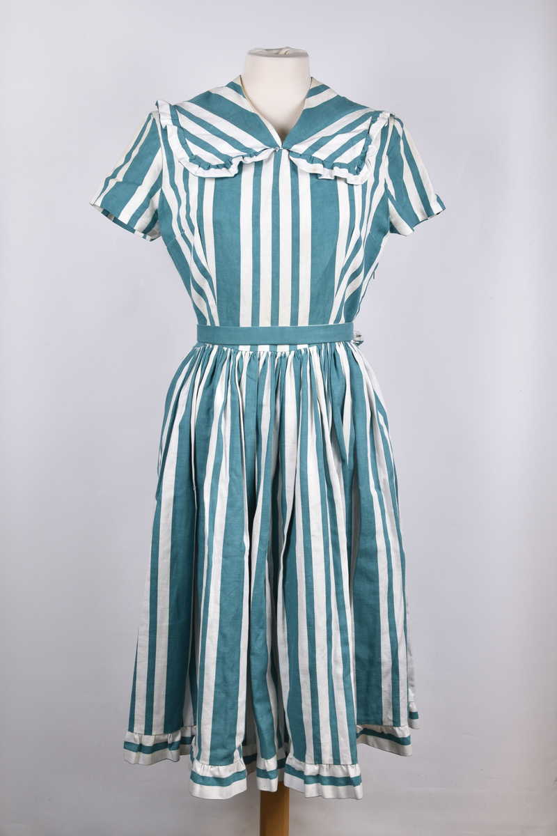 Hjemmesydd russekjole fra 1960 med grønne striper og belte. Hvite mamelukker med blondekant og grønt bånd følger med.
