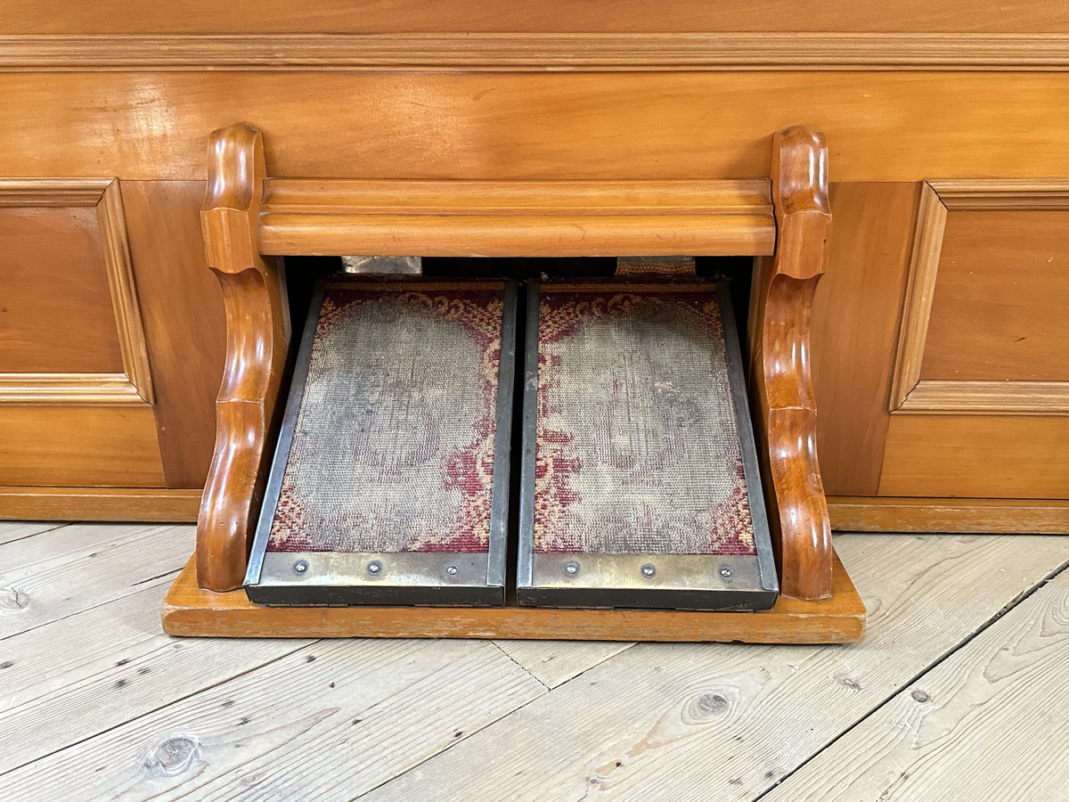 Harmonium i lackat trä. Plant krön, profilerad gavelframkant. Spegel med två dekorativa ljushållare i mässing samt trädekor i form av bär och blad. 14 andrag. Låsbart lock. Klädda trampor i metall. 