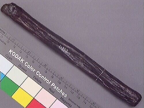 Ett skaft till en hammare. Skaftet är långsmalt och har ett rektangulärt tvärsnitt. Skaftet är avfasat i den ände där hammarhuvudet suttit fästat. Genom skaftets nedre del, som är något förtjockad samt rundad, är ett hål borrat.

Skaftet är slitet. På skaftets mitt syns spår efter en lagning, troligtvis utförd i samband med konserveringen av skaftet.

För mer information se Dokumentationsblankett under Referenser – Länkade filer.

Text in English: The handle or helve of a hammer. The shaft is long and rectangular shaped in cross-section. The end that fits into the hammer head is bevelled, while the other end is somewhat thicker and rounded, with a hole bored through.

The helve is worn and appears to have been repaired at the middle, probably done in connection with its conservation.

For more information see the Documentation form under References – Linked files.