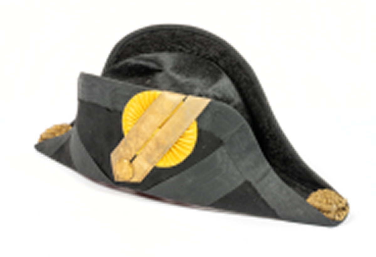 Paradhatt med fodral av trä. Hatten trekantig. Av snart silkesfelb med svarta kantband. Gul kokard med guldgalon och ankarknapp. Buljoner i ändarna. Rödd foder av siden. Firmastämpel (otydlig). Käkrem.