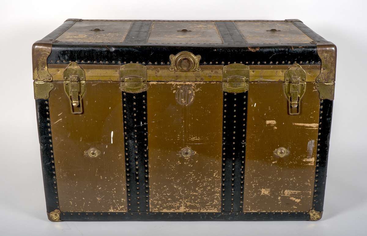 a) Rektangulär resekoffert med trästomme, utvändigt klädd i brunt papp och förstärkt med svartmålat konstläder. Kofferten är försedd med beslag och stötskydd av mässingspläterat stål. På vardera kortsida finns ett bärhandtag av kraftigt brunt läder. Koffertens framsida är försedd med låsanordningar bestående av två haspar samt i mitten ett ofullständigt lås, där låsdelen på kistans underdel saknas.

Invändigt har kofferten en uttagbar låda av papp, vilande på ribbor i kistans övre del. Insidan är klädd med grönt papper i geometriskt mönster. Bottendelen av lådan skyddas av ett smörpapper med blå prickar på vit botten. I kistans botten finns ett skyddande smörpapper med geometriska mönster i vitt, grönt och rött.

På vänster kortsida finns två stycken etiketter:

1. Swedish America Line.
2. Railway Express Agency (Attleboro, Massachusetts). Under denna etikett sitter fragment av en etikett i samma stil.

Se fotografi.

b) Pappersetikett med öljett, fäst i ståltråd: "Svenska.. Amerika. N: 936. Göteborgs Andra Bärarelag".