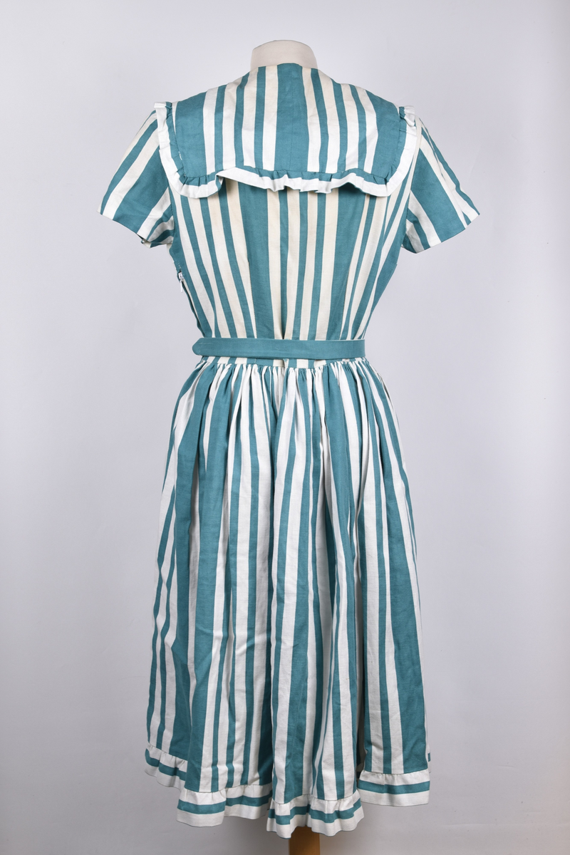 Hjemmesydd russekjole fra 1960 med grønne striper og belte. Hvite mamelukker med blondekant og grønt bånd følger med.
