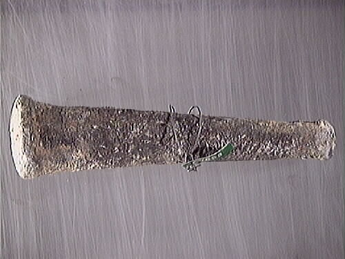 Lod av bly. Fyrkantig profil med avtrubbade ändar. Genomgående hål en den smalare änden har fungerat som ögla. Hålet är fyllt med avlagringar och eventuellt represter. Gråmatt, porös yta.

För mer information se Dokumentationsblankett under Referenser – Länkade filer.