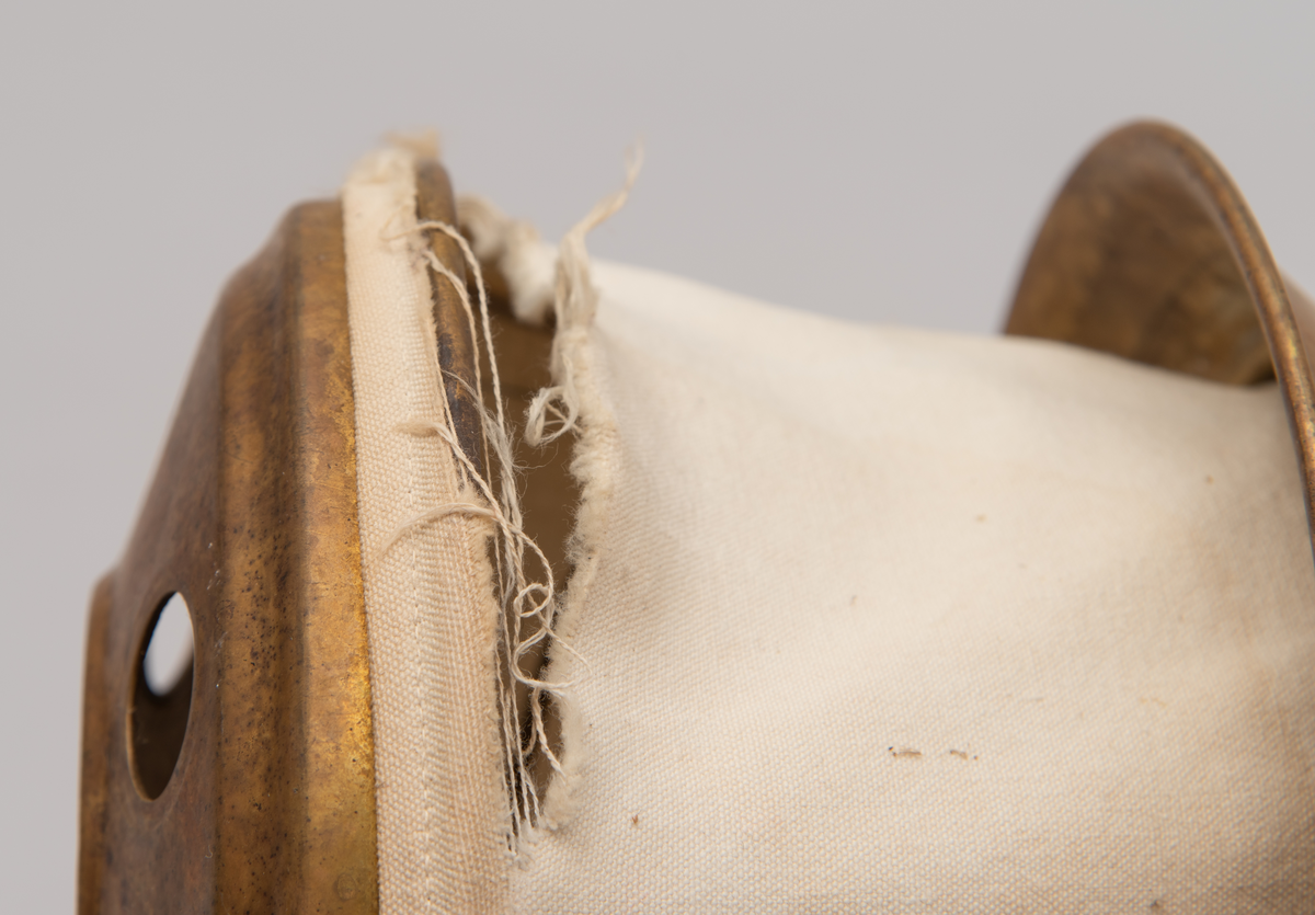 Vaskeredskap bestående av et messingrør til håndtak og et pumpehode i enden. Pumpehodet består av to messinglokk forbundet med et sluttet tekstilbånd, og en metallfjær inni som gir motstand. Nederste lokk har hull for å slippe inn vaskevannet. Godset er stemplet med Rena og initialene O.J.